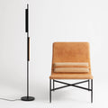 Blu Dot Cowl Floor Lamp in black, 62" tall powder-coated aluminum floor lamp with two pivoting shades, styled beside a tan leather lounge chair