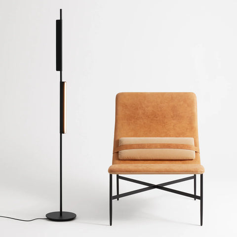 Blu Dot Cowl Floor Lamp in black, 62" tall powder-coated aluminum floor lamp with two pivoting shades, styled beside a tan leather lounge chair