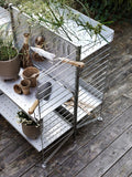 Vertical Double Hook by String™ System in stainless steel mounted on galvanized shelving, holding garden tools and accessories outdoors