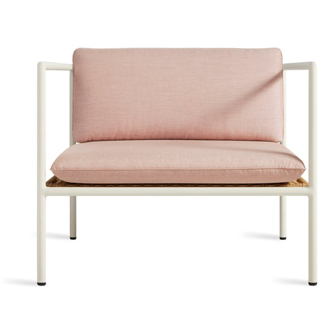 Blu Dot Dog Days Outdoor Lounge Chair in Sunbrella Blush pink cushions with white powder-coated aluminum frame and all-weather rattan