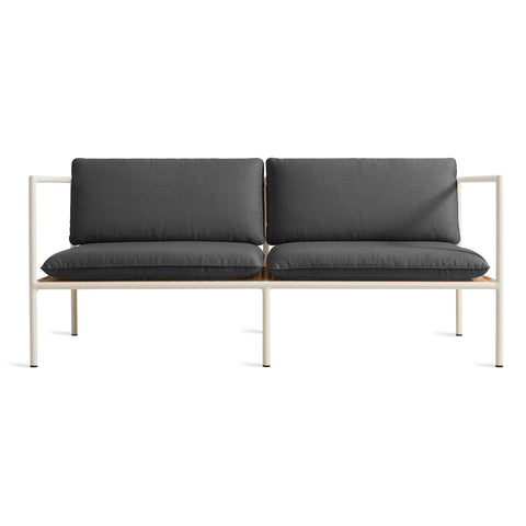 Blu Dot Dog Days Outdoor 2 Seat Sofa in Sunbrella Coal black cushions with white powder-coated aluminum frame and all-weather rattan