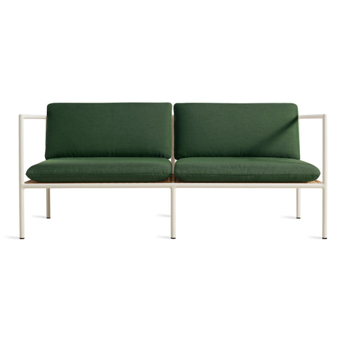 Blu Dot Dog Days Outdoor 2 Seat Sofa in Sunbrella Ivy green cushions with white powder-coated aluminum frame and all-weather rattan