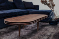 DK3 Groove Coffee Table Oval in smoked oak, angled view in a living room with a dark blue sofa