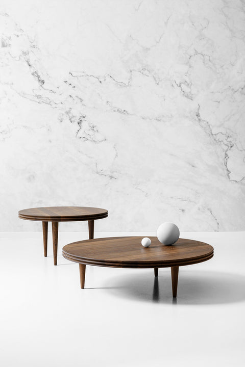 DK3 Groove Coffee Table in smoked oak, two round tables on tapered wooden legs against a marble wall