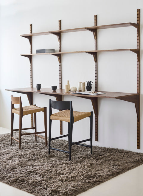 DK3 Pia Counter Stools at a System Cado desk on a rug, one in smoked oak and one in black lacquered oak