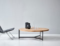 DK3 Plateau Coffee and Side Table in oiled oak beside a black leather lounge chair in a white room