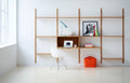 DK3 Royal System wall shelving in oiled oak with a small cabinet, a desk lamp and a white chair