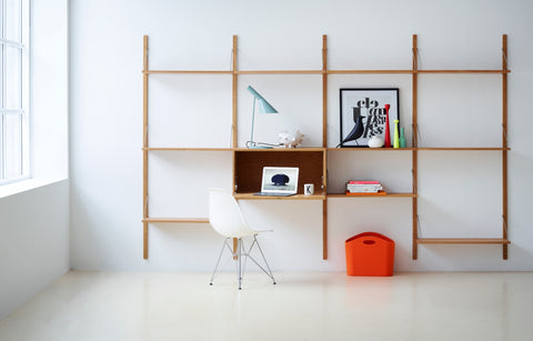 DK3 Royal System wall shelving in oiled oak with a small cabinet, a desk lamp and a white chair