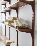 DK3 System Cado smoked oak shelves with stacked books, close view