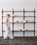 DK3 System Cado smoked oak shelving with a woman walking past