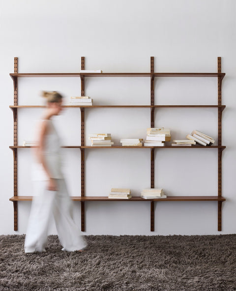 DK3 System Cado smoked oak shelving with a woman walking past