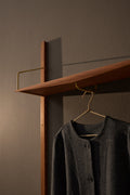 DK3 System Ultra shelf with a clothes rail in walnut, a coat on a hanger