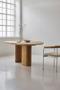 DK3 Tangent Table Round in oiled oak beside a window with an upholstered chair