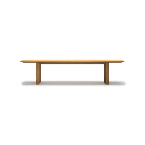 DK3 Ten Bench in Oiled Oak, solid wood dining bench with grooved legs and a curved top, side view on white