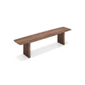 DK3 Ten Bench in Walnut, solid wood dining bench with grooved legs and a curved top, angled view on white