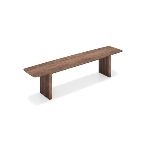 DK3 Ten Bench in Walnut, solid wood dining bench with grooved legs and a curved top, angled view on white