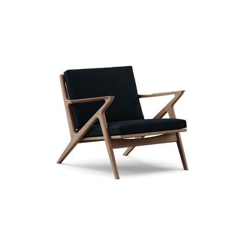 DK3 Z Chair in Alpaca Midnight Blue 1108 and Walnut, fabric lounge chair with a Z-shaped solid wood frame, angled view on white