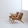 Two DK3 Z Chairs in oiled oak with cognac leather, angled view