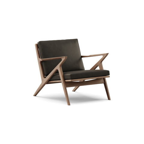 DK3 Z Chair in Rio Leather Black 0500 and Walnut, leather lounge chair with a Z-shaped solid wood frame, angled view on white