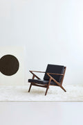 DK3 Z Chair in walnut with dark brown leather on a white rug