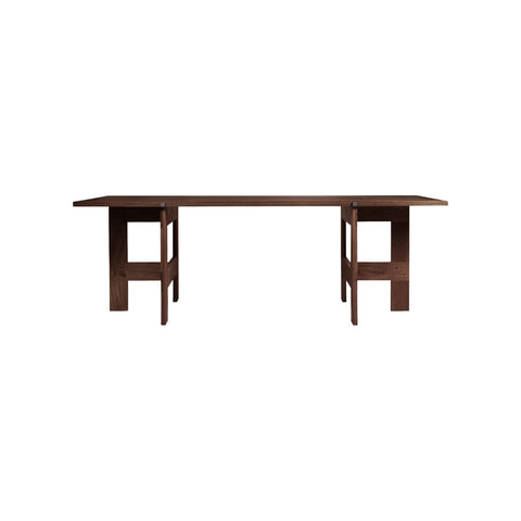 Frama Farmhouse Trestle Table in Dark Oak, long dark oak top resting on two trestles, seen from the side against white