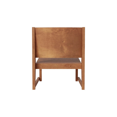 Frama Easy Chair 01 in Warm Brown Birch, warm brown low chair with a broad back panel and open sides, front view on a white ground