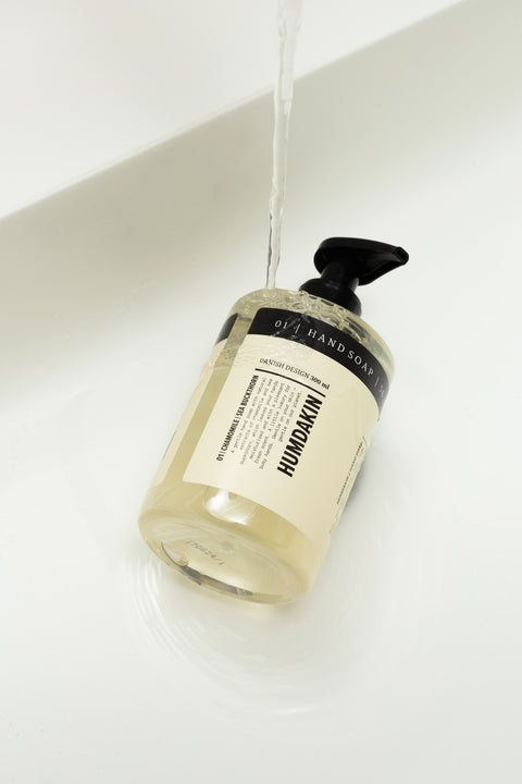 Humdakin 01 Hand Soap, Chamomile & Sea Buckthorn, liquid hand soap, bottle lying in a white basin under running water