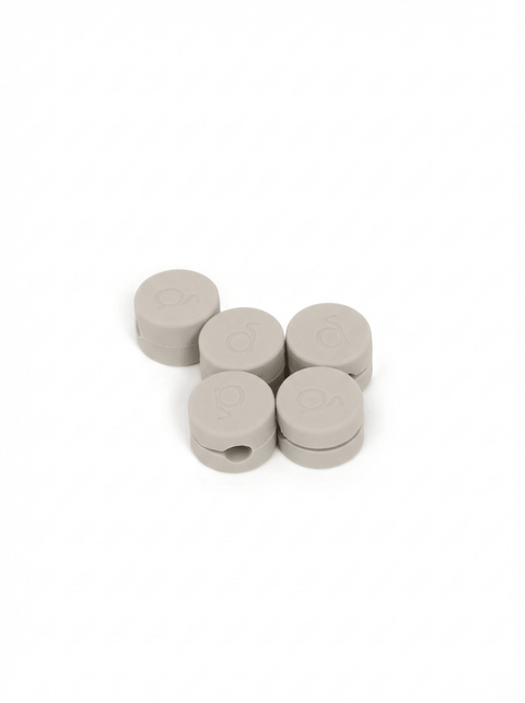 Pedestal Cable Clips in Oat, five magnetic silicone cable clips grouped together, on a plain white background