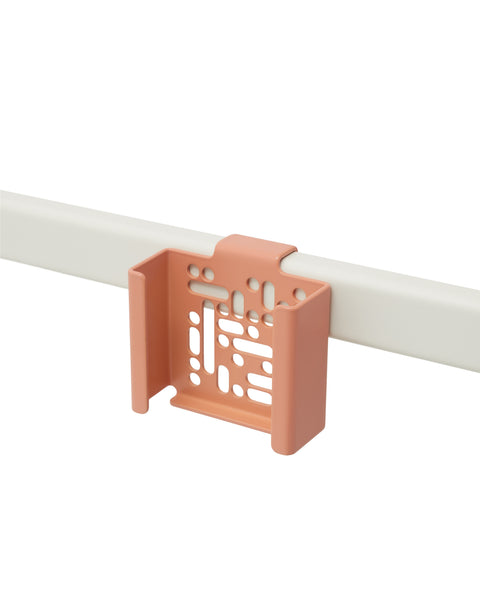Pedestal Apple TV Mount in Dusty Rose, perforated steel Apple TV bracket on a stand tube, on a plain white background