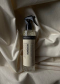 Humdakin Fabric Spray 2-in-1, Chamomile & Sea Buckthorn, textile refresher spray, bottle lying on a white bedsheet