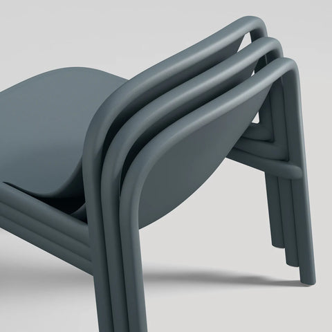 Blu Dot Decade Lounge Chair in marine blue recycled plastic, close-up showing three chairs stacked together demonstrating the stackable design