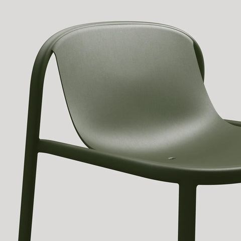 Blu Dot Decade Lounge Chair in olive green recycled plastic, close-up showing the seamless molded seat and back with integrated drainage hole