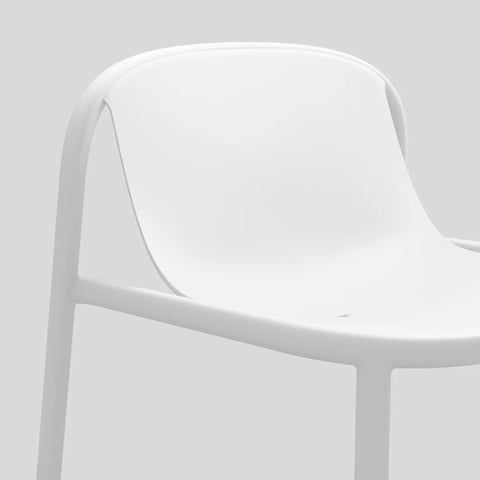 Blu Dot Decade Lounge Chair in white recycled plastic, close-up showing the seamless molded seat and back with integrated drainage hole