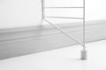 White floor panel extension attached to String® System panel, detail view at baseboard