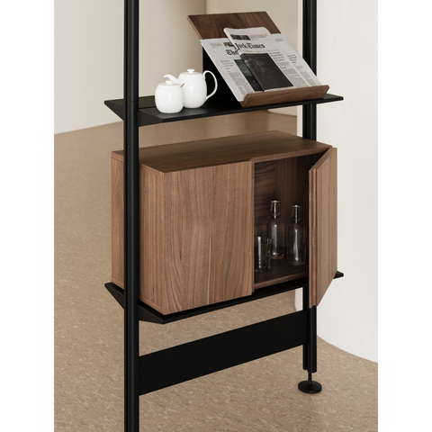 String Furniture Pira shelving with a walnut cabinet and black poles, modular shelving detail with books