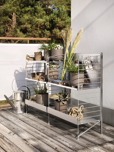 Outdoor shelving unit with galvanized 33.5"H floor panels from String™ System styled with plants and garden tools
