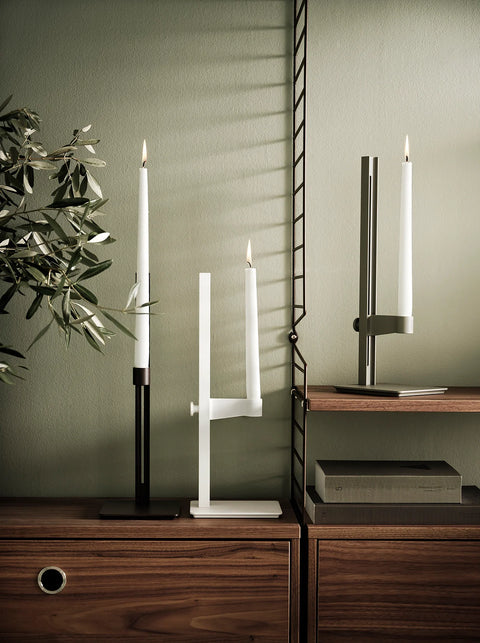 White and green Museum Candle Holders styled on String™ shelving system with wooden cabinets and olive branches.