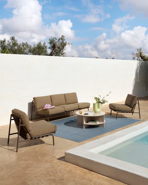 Muuto Settle outdoor sofa and lounge chairs in taupe with round coffee table on terrace