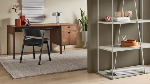 Blu Dot Cursive Desk in walnut styled in a modern home office with shelving unit and side chair