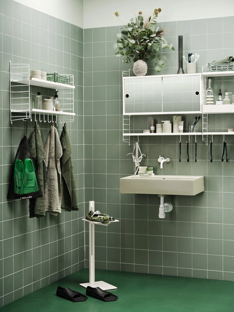 White Museum Side Table styled in green tiled bathroom with String® System shelving
