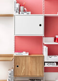 White and oak Cabinet with Swing Doors in String® System against pink wall