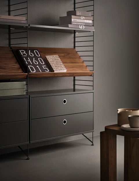 String™ modular shelving system with Magazine Shelf in walnut finish, styled with books and drawers in black