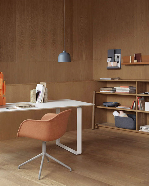 scandinavian minimalist interior with wood panel wall and swivel chair by muuto 