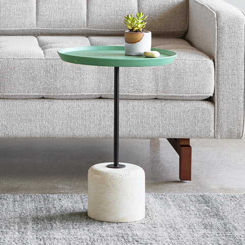 Gus* Modern Agency Table, round side table, Robusta green top on a travertine base in front of a grey tufted sofa