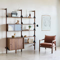 Gus* Modern Branch-2 Multi Storage Unit with Shelves, walnut wall storage with cabinets beside a Humber Lounge Chair in Regency Beet