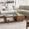 Gus* Modern Conway Coffee Table, walnut coffee table with books in the open cubby, in front of a sectional sofa