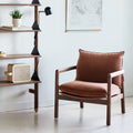 Gus* Modern Humber Lounge Chair, walnut lounge chair, Regency Beet beside walnut shelving and a black floor lamp