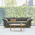 Gus* Modern Zoe Sofa, grey upholstered sofa with oak legs, Rosslyn Legacy beside a round wood coffee table by a large window