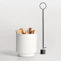 Carry Firewood Carrier by Blu Dot in white powder-coated aluminum, styled with firewood and Pokey von Pokerson Fire Poker