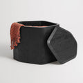 Black-stained acacia Hoard Tall Side Table with Storage with the removable top set aside, revealing a throw blanket inside